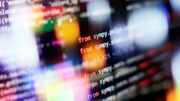 Abstract software source code on screen representing build vs buy technology decisions