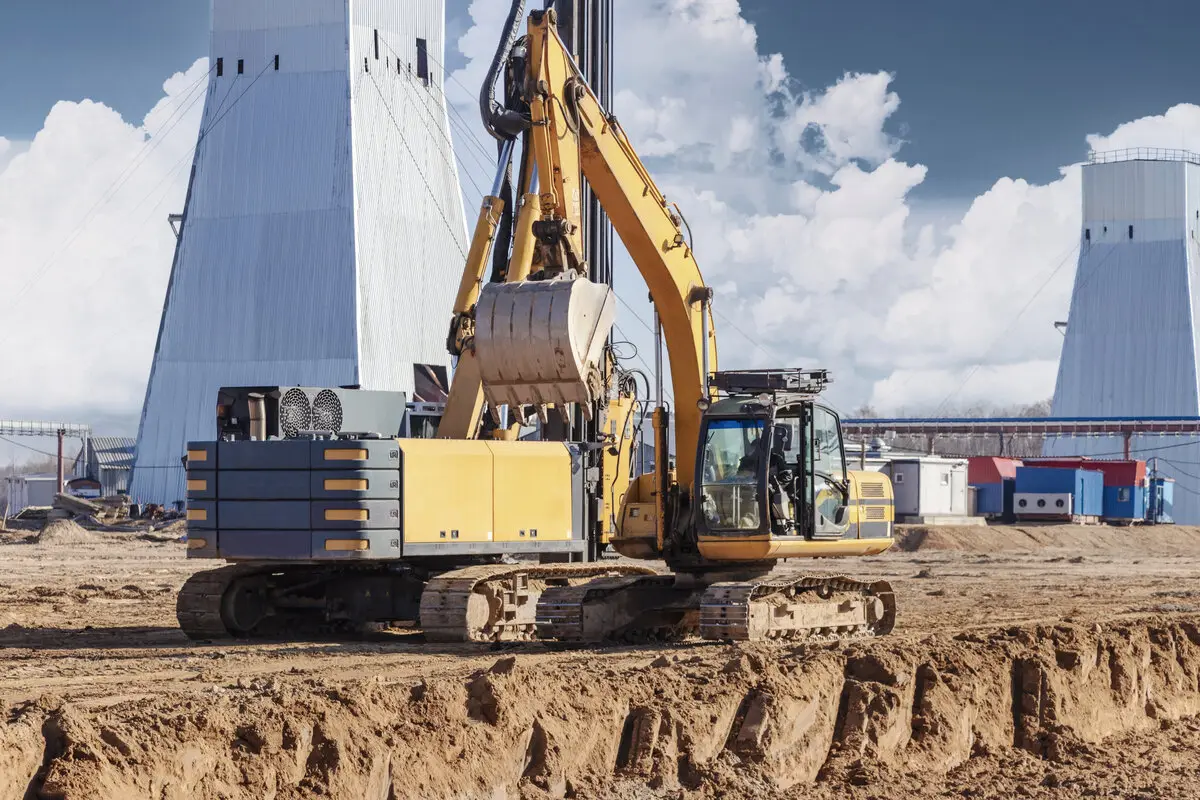 Heavy construction machinery and excavator at job site representing construction tech solutions