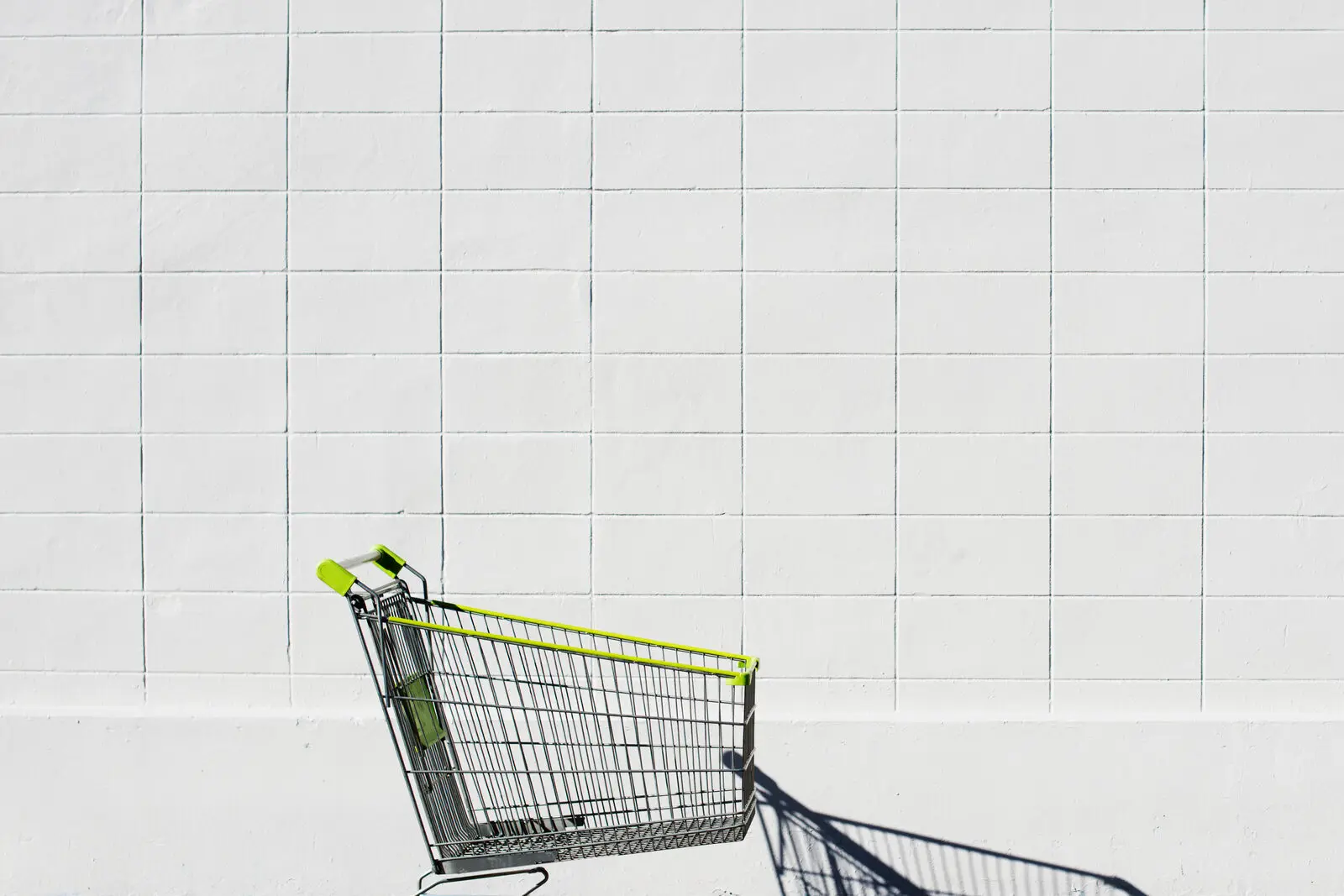 An abandoned shopping trolley tipped against a white wall, representing cart abandonment in an online store