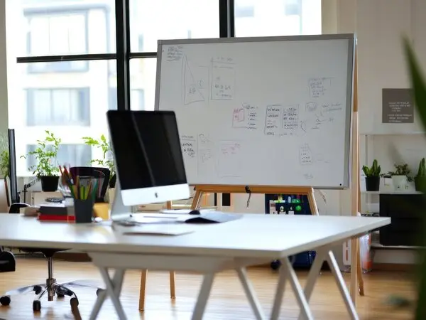 Modern office workspace with technology strategy whiteboard and desktop computer for fractional CTO planning