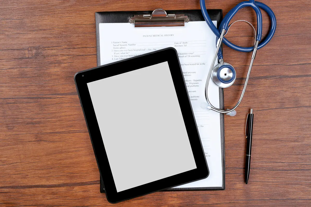 Electronic health records system with stethoscope and clipboard on medical office desk