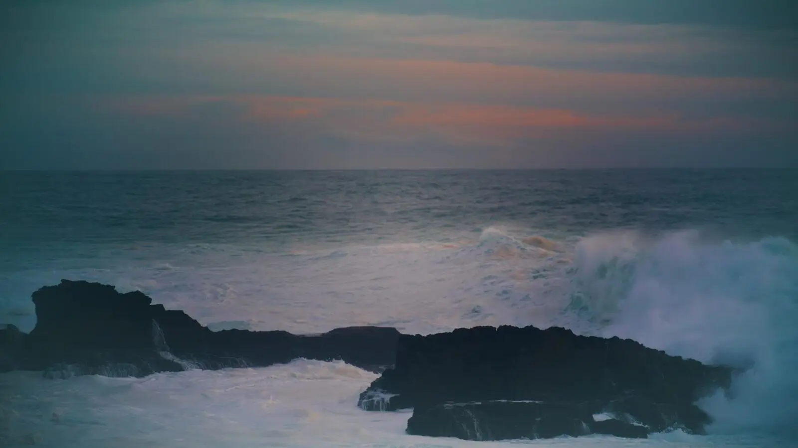 Dramatic ocean waves and dark skyline representing EdgeWater Boats premium marine brand