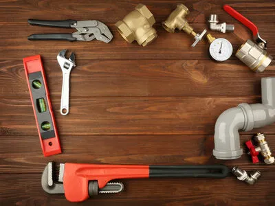 Plumbing tools on wooden surface representing home services