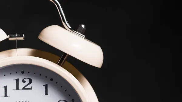 A vintage alarm clock against a black background, representing the narrow window a business has to respond to a new lead