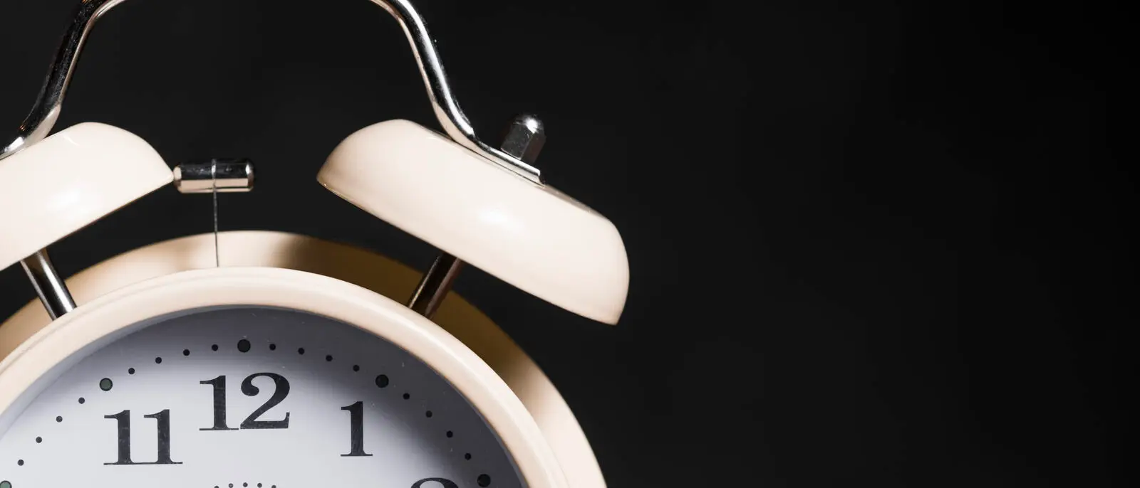 A vintage alarm clock against a black background, representing the narrow window a business has to respond to a new lead
