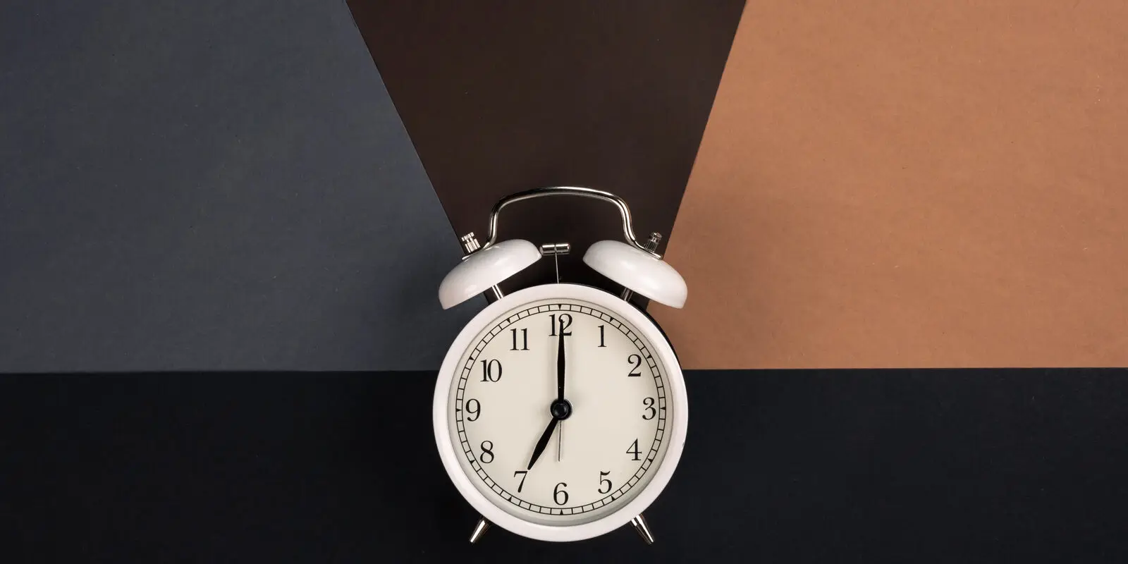 An alarm clock photographed from above on a dark background, representing measuring response time to new business inquiries