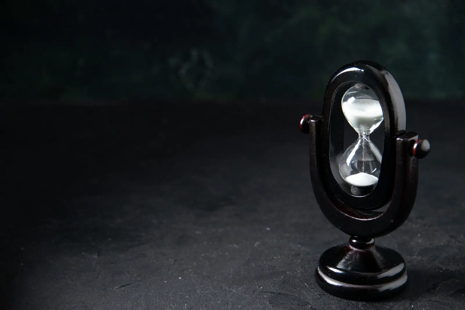 An hourglass on a dark surface, representing the narrow window in which a new sales lead stays responsive