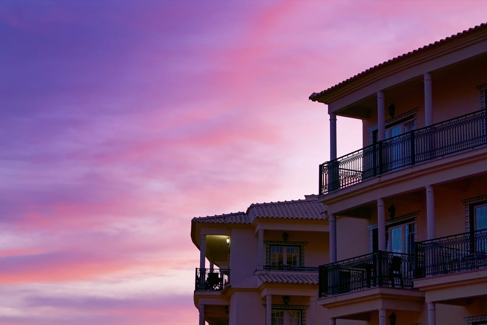 Apartment building with balconies at sunset, representing residential property management and rental operations